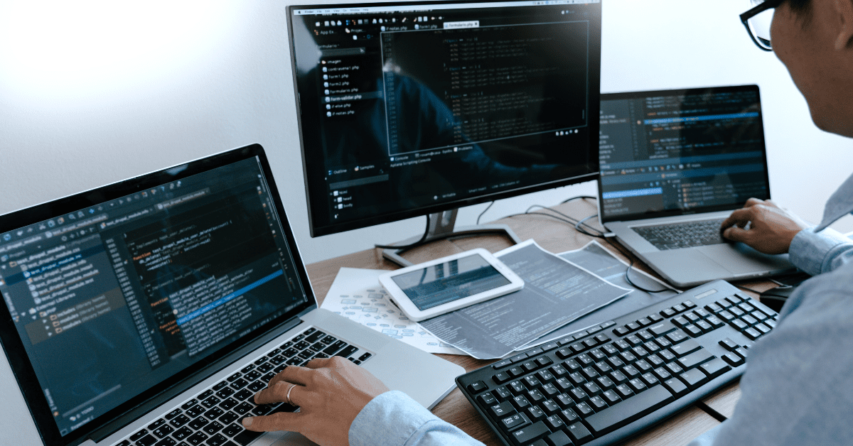 A developer working on AI-related code across several screens and devices, highlighting the complexity and integration of modern AI software development.