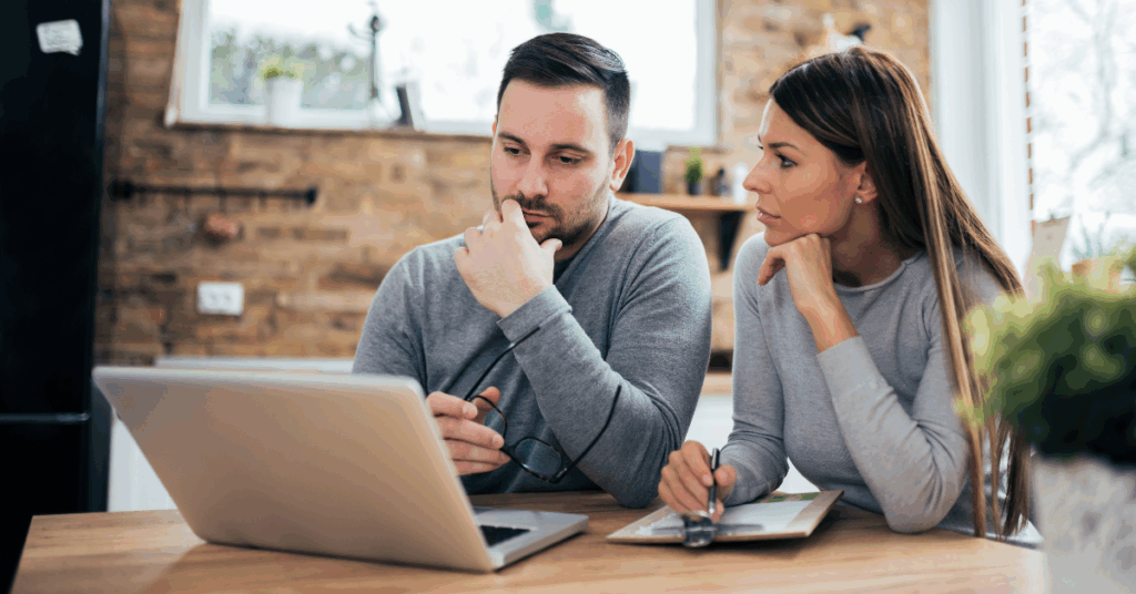 Thoughtful couple looking at a laptop, symbolizing CTOs or decision-makers evaluating better alternatives to gig platforms for development needs.