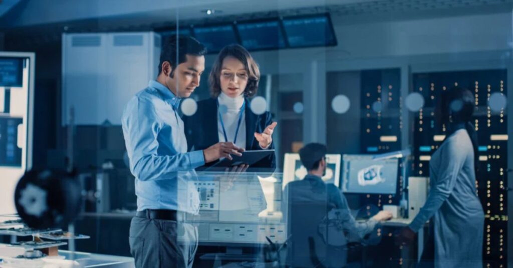 Two professionals reviewing data on a tablet in a modern AI development lab.