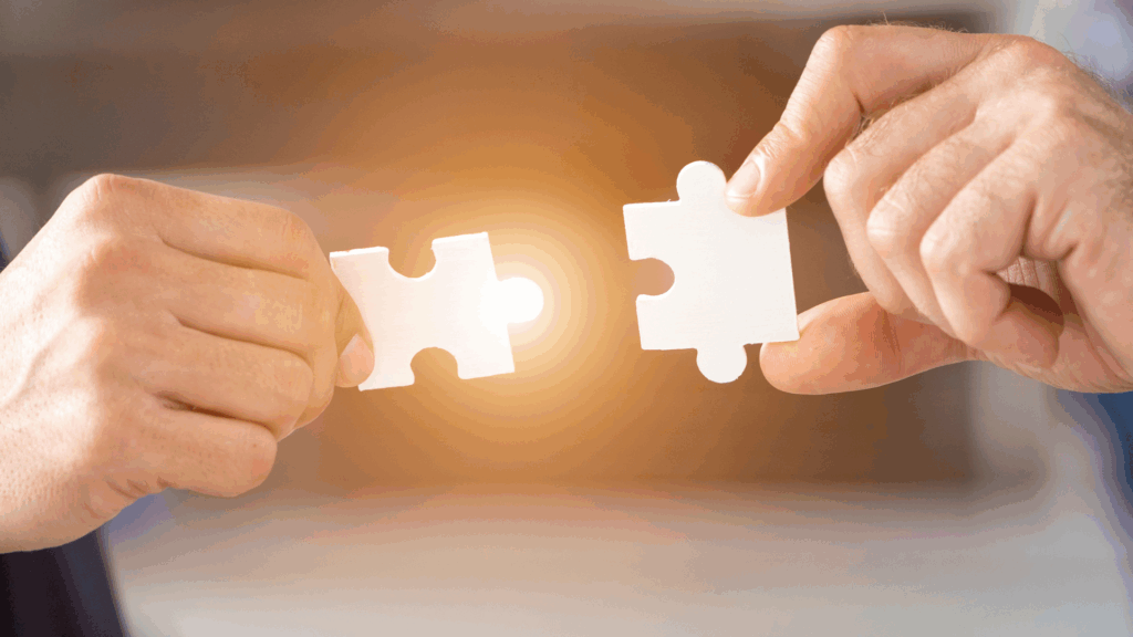 Close-up of two hands joining puzzle pieces, symbolizing strategic nearshore partnership