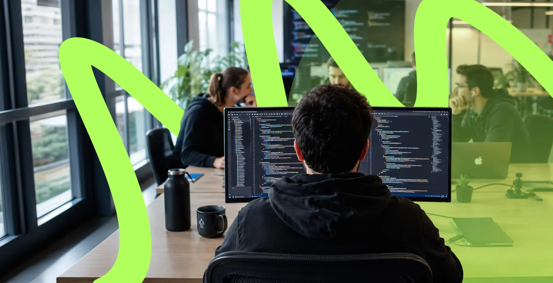 parallelstaff- A person sits at a desk working on a computer with code on the screen in a modern office, while others collaborate in the background. Bright green graphic elements overlay the image.
