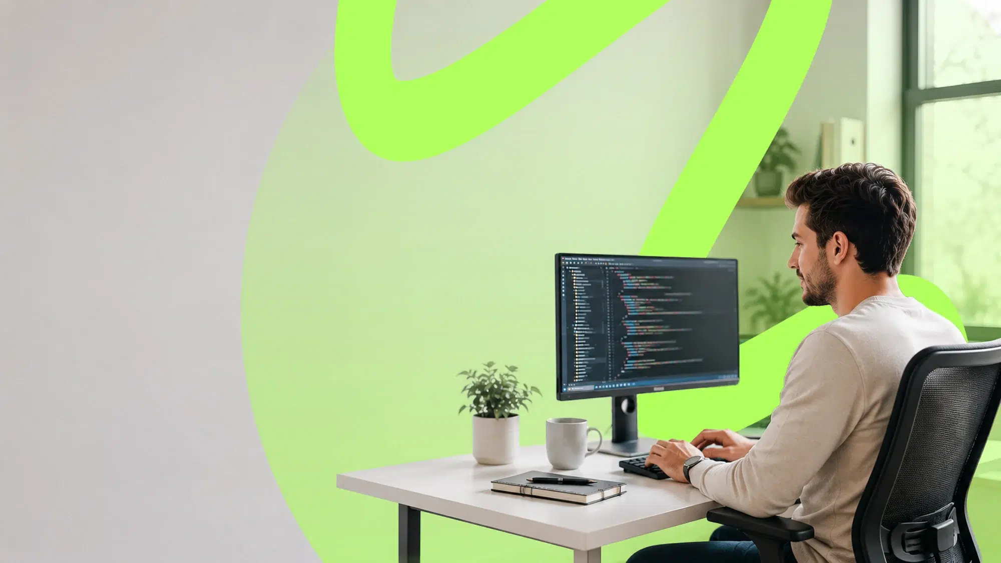 parallelstaff- A person sits at a desk working on a computer with code on the monitor. There is a plant, a notebook, and a mug on the desk. The background features a large green abstract design on the wall.