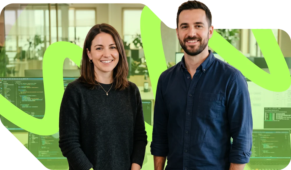 parallelstaff- Two people, a woman and a man, stand smiling in an office environment with computer monitors in the background. A green abstract line is overlaid across the image, and the scene appears modern and professional.