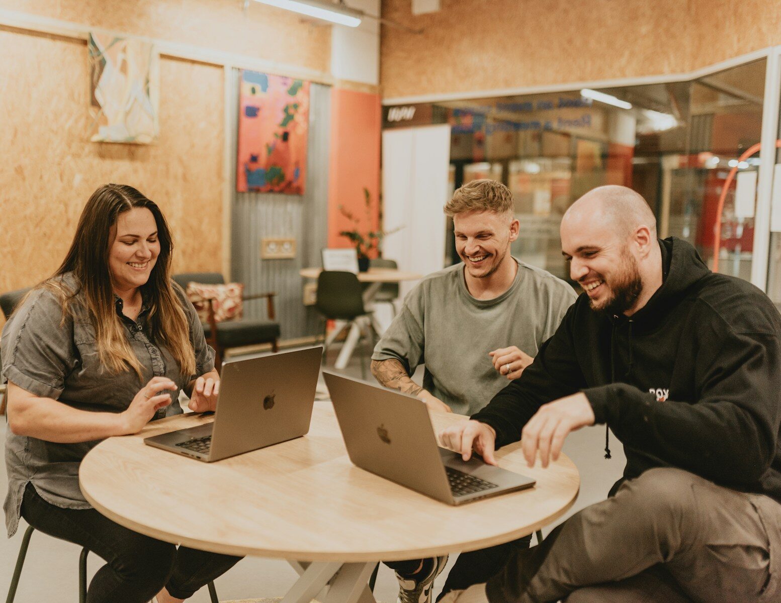 Three people are working and laughing together.