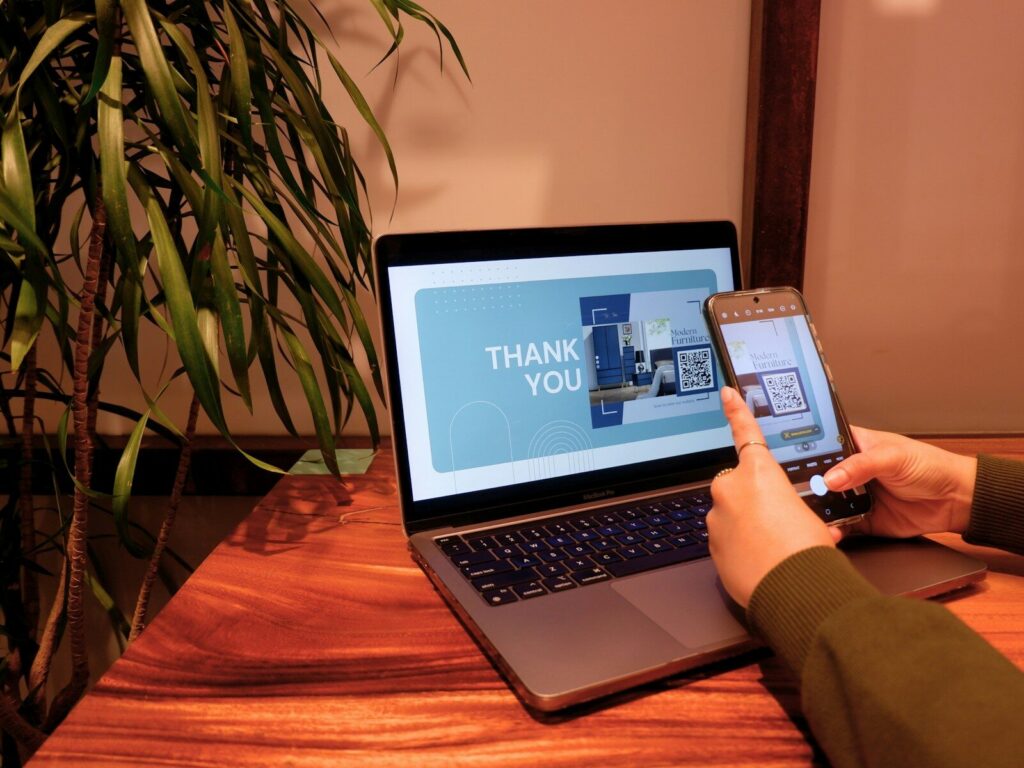 a person using a cell phone and laptop computer