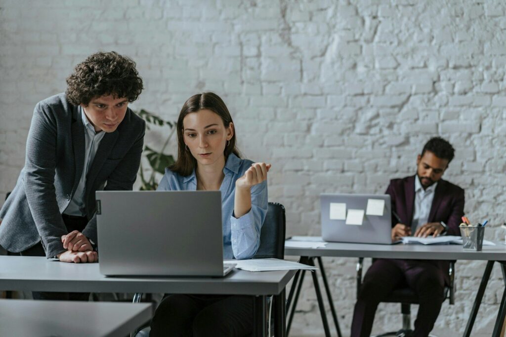 Two colleagues collaborating on a laptop in office